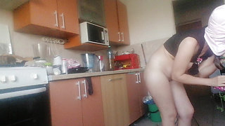 Sexy wife having fun in the kitchen with roses. Sexy naked wife preparing food in the kitchen.