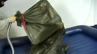 Woman struggling in a green latex bag