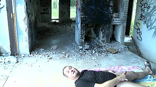 In the squalor of a ruined building, a busty whore gets fucked