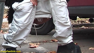 Girl peeing between the cars