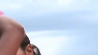 Dark haired beauties enjoy a threesome with a hung hunk on the beach