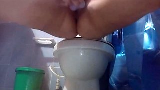 Wet Blonde masturbates her pussy on a toilet with her dildo