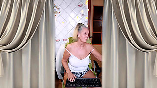 A cheerful housewife twerks in the kitchen near the washing machine and beckons with her bare feet.