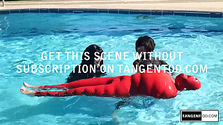 TANGENTOD Women in Black Catsuits Float Red Latex Encased Figure on Inflatable Rubber Pool Toy