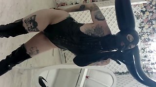 Lady Lazarus in a horned latex mask shows off with a PVC striptease