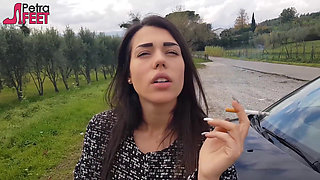 Outdoors smoking cigar from sexy brunette