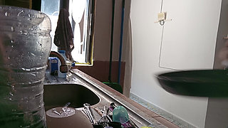 Mother-in-law cleans in the kitchen in bra